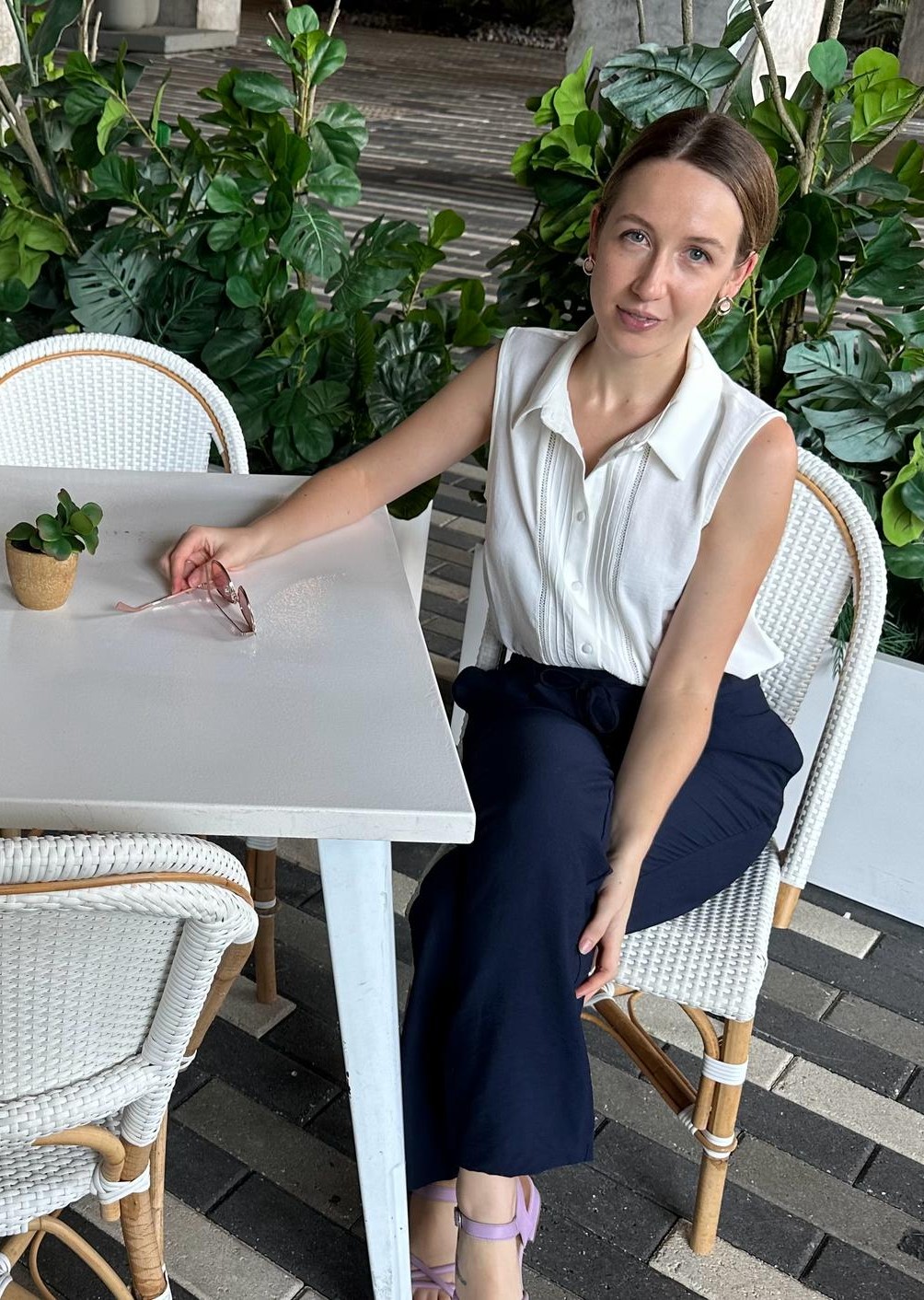 Laura, linguistique anglaise, assise à une table offrant des services professionnels de correction de documents pour les francophones.
